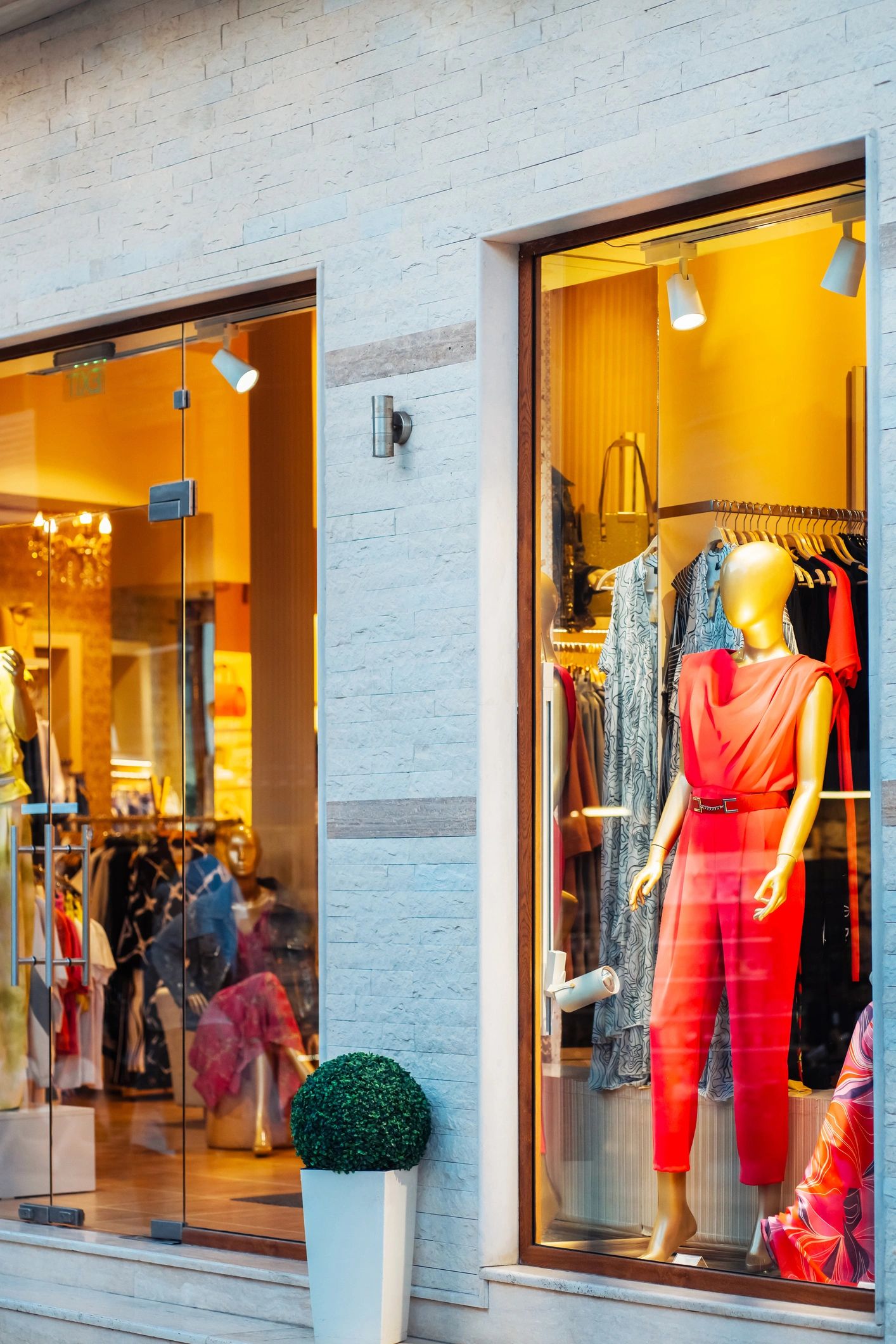 A bright boutique window showcases a red outfit